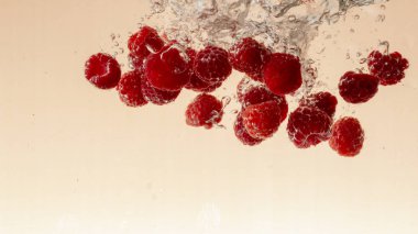 Ahududu meyve su portakal pastel arka planda sıçrama yapma yakın çekim