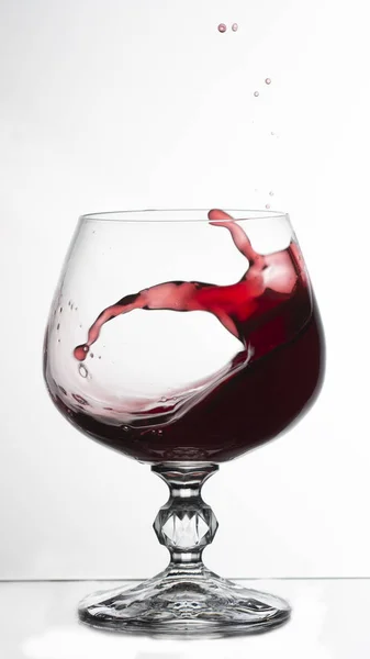 Κόκκινο Κρασί Πιτσιλίζει Από Ένα Ποτήρι Απομονωμένο Λευκό — Φωτογραφία Αρχείου