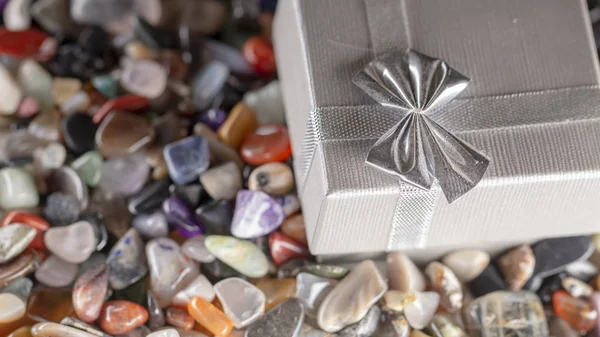 Gift box with semiprecious stones close-up background