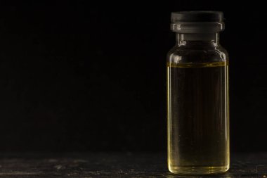 sarı içinde bir siyah arka plan, yakın çekim, seçici odak ile küçük tıbbi şişe