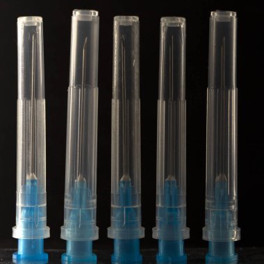 Çok renkli bir şırınga siyah bir zemin üzerine plastik kapakları kafasına tıbbi iğne yakın çekim