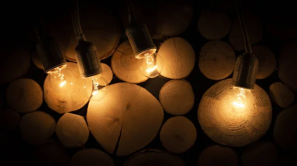 Dunkle Glühbirne Auf Dem Hintergrund Einer Hölzernen Blockwand — Stockfoto