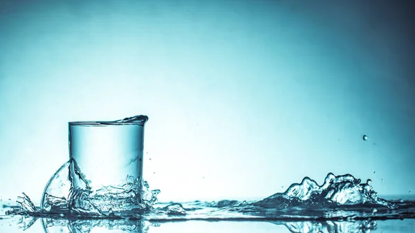 Acqua Potabile Pura Con Spruzzi Bicchiere Rotondo Uno Sfondo Verde — Foto Stock