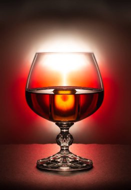 Bir bardak brendi kırmızı bir arka plan üzerinde Kapat