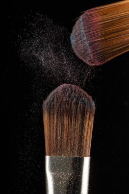 toz sıçrama ve fırça siyah arka planda makyaj sanatçısı veya güzellik blogcusu için