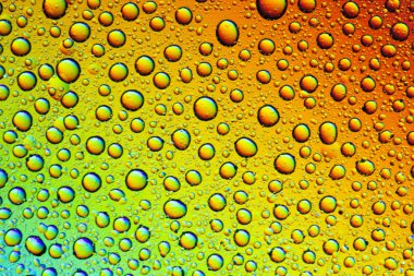 Gökkuşağının yansımasıyla camın üzerine su damlaları. Arka plan