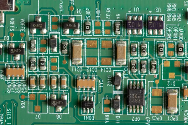 Grüne Computerplatine mit verschiedenen Elektronikelementen. Textur — Stockfoto