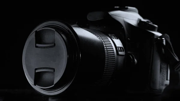 professional digital photo camera against black background close up