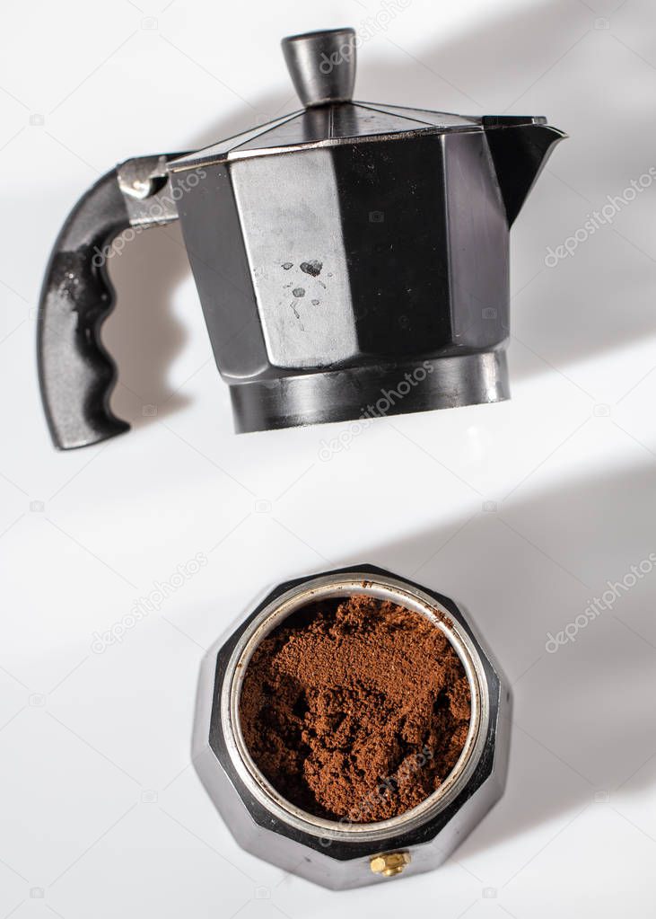 black geyser coffee maker with ground natural coffee inside on a white background