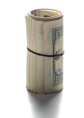 100 dolarlık banknotlar tüpe bükülmüş ve elastik bir bantla bağlanmış. beyaz arka plan. Yakın çekim