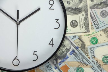 Yüz dolarlık banknotlar ve beyaz büyük bir saat, kavram, zaman para arka plan yakın