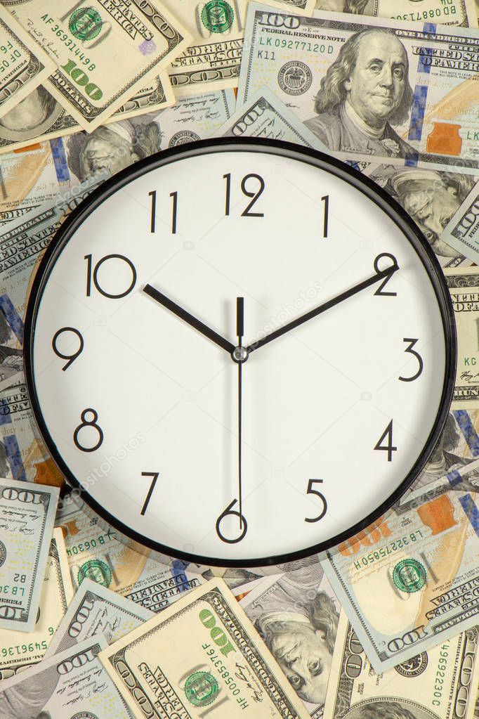 One hundred dollar bills and a white big clock, concept, time is money background close up