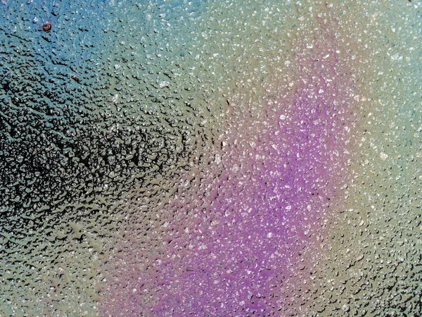 Flerfärgad oljeutsläpp på asfaltväg, abstrakt bakgrund, — Stockfoto