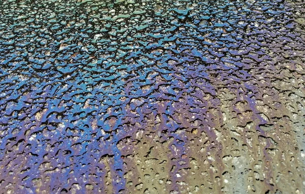Több színű olajfolt az aszfaltúton, absztrakt háttér, — Stock Fotó