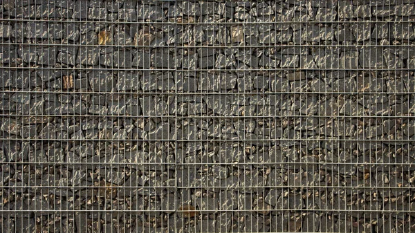 Gabion – Kamenná stěna s kovovou mřížkou z šedé žulové textury — Stock fotografie