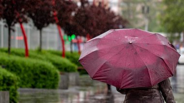 İnsanlar şehrin sokakta yağmurlu bir günde şemsiye altında yağmurdan gizlemek Kötü hava kavramı