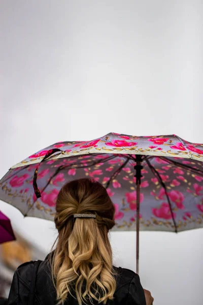 As pessoas se escondem da chuva sob guarda-chuvas em um dia chuvoso na rua da cidade Conceito de mau tempo — Fotografia de Stock