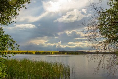 Küçük bir göl üzerinde yağmur, bir tarım arazisi kraliyet alanı ile