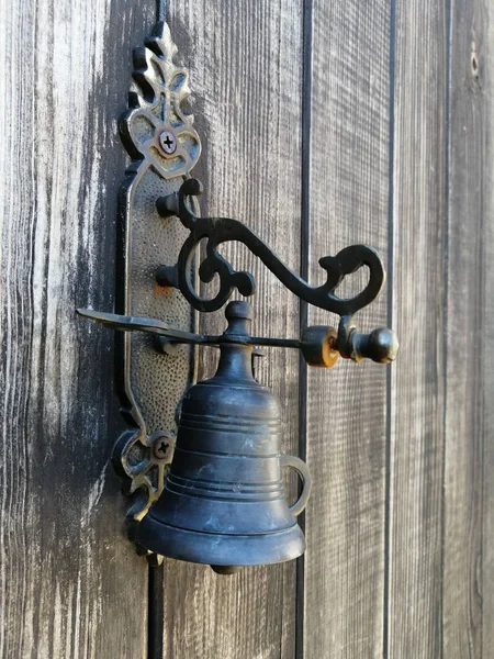 Antique bronze bell on an old wooden door
