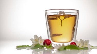 beyaz bir arka plan üzerinde şeffaf bir cam termomug yasemin ile yeşil çay