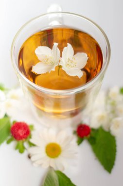 beyaz bir arka plan üzerinde şeffaf bir cam termomug yasemin ile yeşil çay