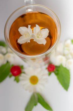 beyaz bir arka plan üzerinde şeffaf bir cam termomug yasemin ile yeşil çay