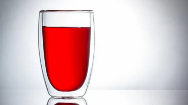 Líquido vermelho sobre um fundo branco, suco ou chá . — Fotografia de Stock