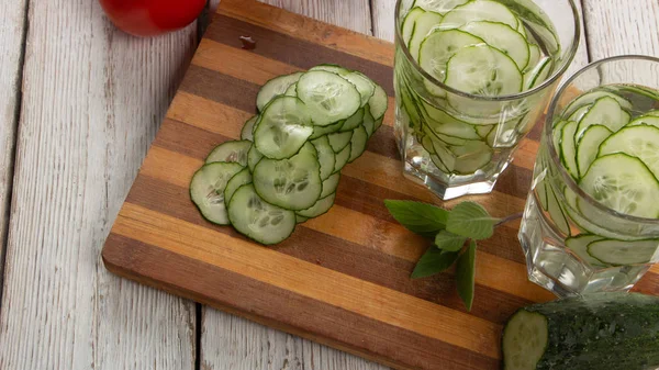 Salatalık suyu, vücudu detoks ve beyaz bir arka plan üzerinde susuzluk gidermek için temizlik su.