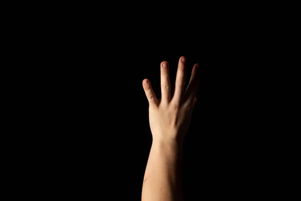 En ung mands hånd på en sort baggrund - Stock-foto