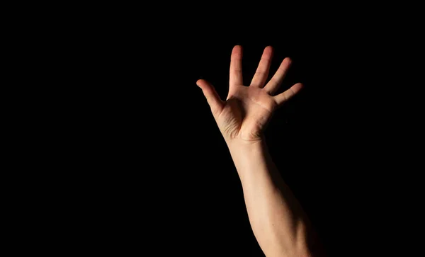 Die Hand eines jungen Mannes auf schwarzem Hintergrund — Stockfoto