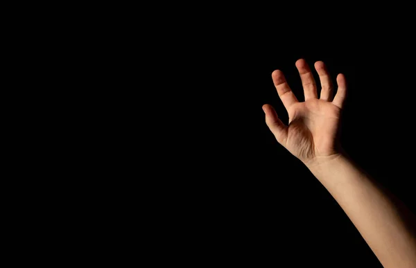 En ung mands hånd på en sort baggrund - Stock-foto