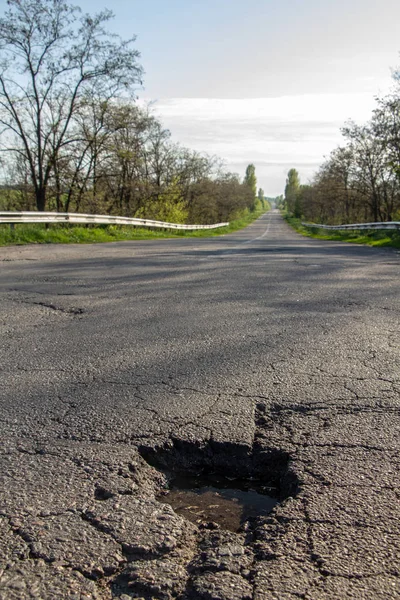 There are many potholes on the roadway close up — Stock Photo, Image