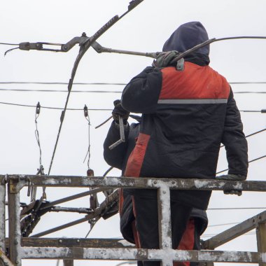 Kuledeki işçiler, tramvay otobüsleri için iletişim şebekesini onarıyor