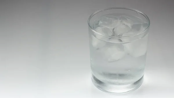 Eis im Glas auf grauem Hintergrund — Stockfoto