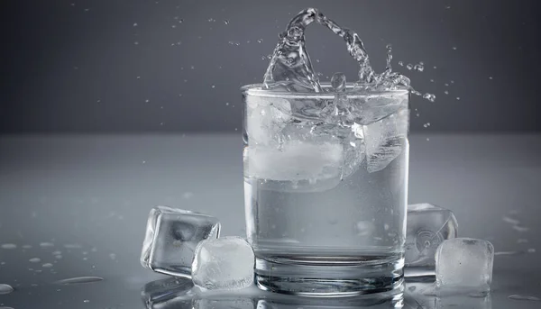 Gießen von Wasser in Glas auf blauem Hintergrund Nahaufnahme — Stockfoto