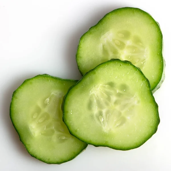 Verse groene komkommer, gesneden met ringen op een witte achtergrond — Stockfoto