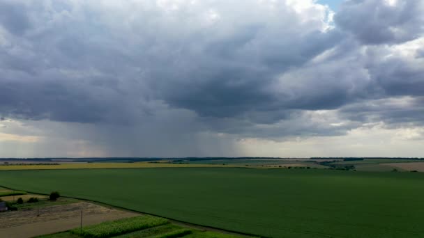 Vídeo aéreo, chuva sobre os campos agrícolas, que pode destruir a colheita, uma bela paisagem rural . — Vídeo de Stock