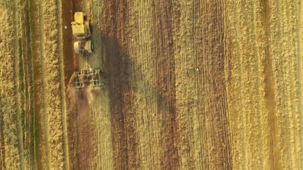 4k古旧的拖拉机耕种一片黄色的田地。 空中录像 — 图库视频影像
