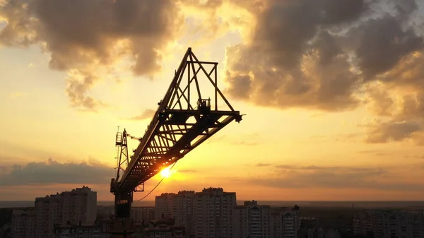 Průmyslové stavební jeřáby a stavové siluety nad pozadím a východem slunce. — Stock fotografie