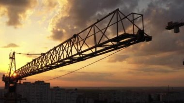 Sabah gökyüzüne karşı rüzgarda hafifçe sallanan bir vinç. Yakın çekim, hava görüntüsü