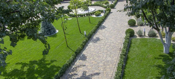 Pavimentazione lastra di cemento ciottolato pista in un giardino ben curato — Foto Stock