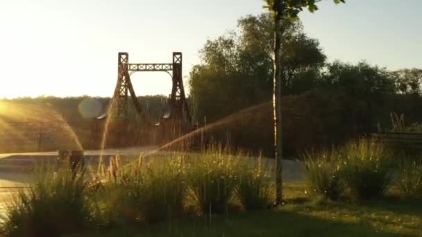 Die rote Metallbrücke über einen kleinen Fluss am Damm der Stadt Irpin in der Ukraine, niedriger langsamer Drohnenflug — Stockvideo