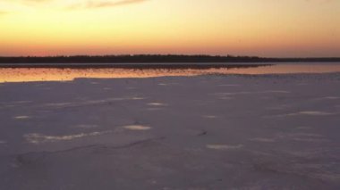 4k, Tuzla tuz gölünde gün batımı, martılar rezervuar yüzeyinde oturup gölün üzerinde uçmak.