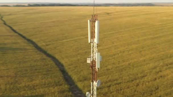Tiroteio de um drone voando em torno de uma torre de repetidor móvel em uma área rural — Vídeo de Stock