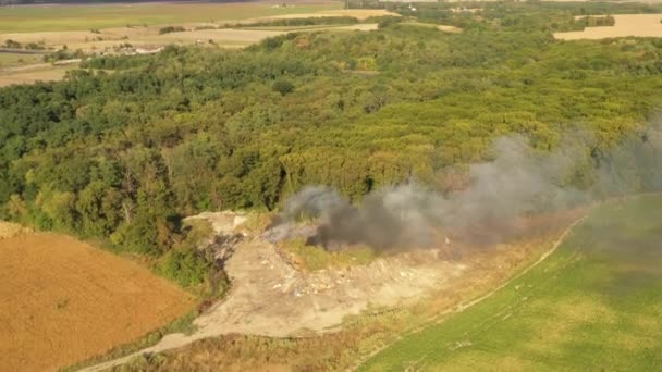 The garbage dump near the forest burns. Poor ecology, emissions into the atmosphere. — Stock Video