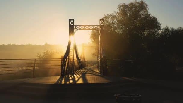 A vörös fém híd felett egy kis folyó a töltés a város Irpin Ukrajnában, alacsony lassú drón repülés — Stock videók
