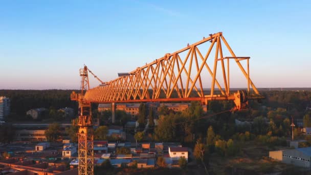 Um guindaste de construção balançando ligeiramente no vento contra o céu da manhã. Close-up, vídeo aéreo — Vídeo de Stock