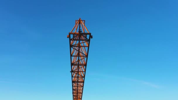 Une grue de chantier se balançant légèrement dans le vent contre le ciel du matin. Gros plan, vidéo aérienne 