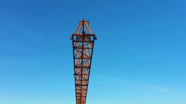 Una gru da costruzione ondeggia leggermente nel vento contro il cielo del mattino. Primo piano, video aereo — Video Stock