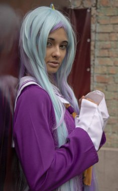 26 Eylül 2018, Ukrayna Kiev: Çağdaş Pop Kültür Festivali. Comic Con. Mor elbiseli ve turkuaz peruklu çekici bir kızın portresi. Etkinlik sırasında ne poz.